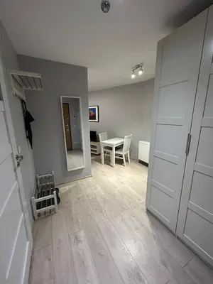 an empty room with a table and a white door at Solna Studio Apartment - Comfort Stay in Heart of Kraków in Kraków