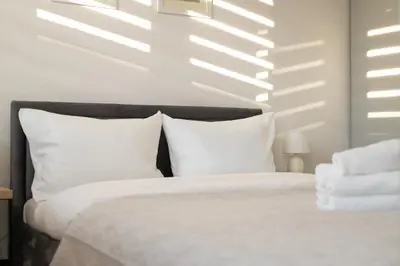a bedroom with a white bed with white pillows at Ciesielskiego Cozy Studio by BookingHost in Kraków