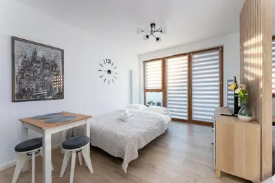 a bedroom with a bed and a table and chairs at Ciesielskiego Cozy Studio by BookingHost in Kraków