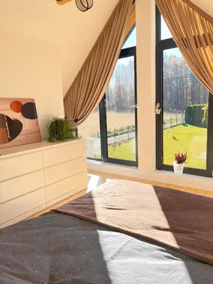 a bedroom with a large window with a view of a field at Słoneczny Zakątek 2025
