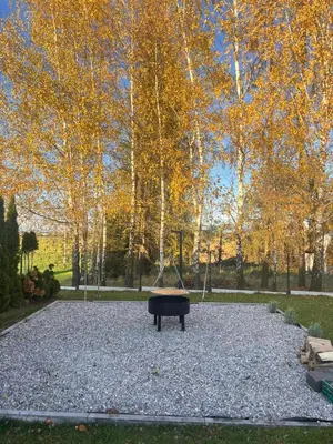 a large gravel area with a bench in a park at Słoneczny Zakątek 2025