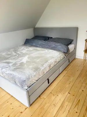 a bed in a room with a wooden floor at Słoneczny Zakątek 2025