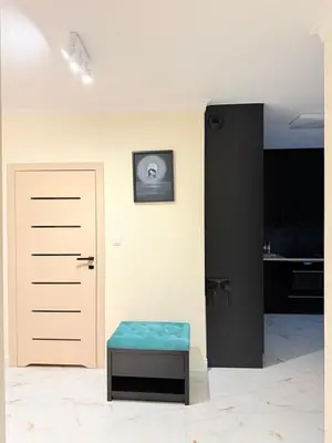 a white room with a door and a stool at Prywatny apartament przy ulicy Francesco Nullo in Kraków