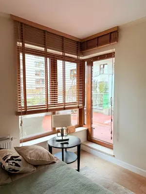 a bedroom with a bed and a table with a lamp at Prywatny apartament przy ulicy Francesco Nullo in Kraków