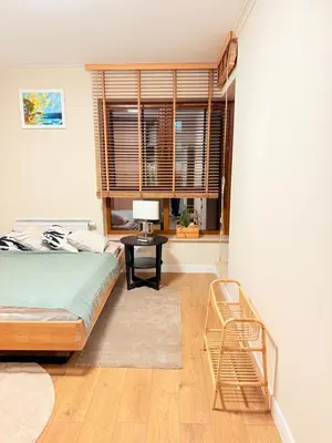 a bedroom with a bed and a table and a window at Prywatny apartament przy ulicy Francesco Nullo in Kraków