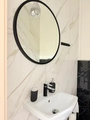 a bathroom with a white sink and a mirror at Prywatny apartament przy ulicy Francesco Nullo in Kraków