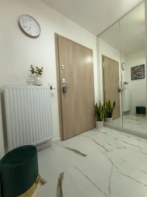 a room with a door and a clock on the wall at Apartament Dobrego Pasterza 46 Free Parking in Kraków