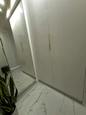 a white bathroom with a mirror and a plant at Apartament Dobrego Pasterza 46 Free Parking in Kraków