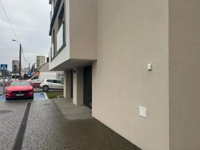 a red car parked in a parking lot next to a building at Apartament Dobrego Pasterza 46 Free Parking in Kraków