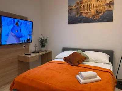 a bedroom with a bed and a flat screen tv at Old Town Apartments B15 in Kraków