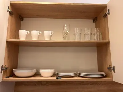 a wooden shelf with dishes and glasses on it at Old Town Apartments B15 in Kraków