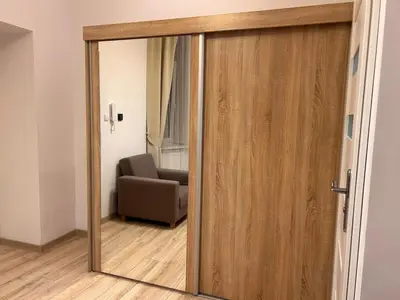 a sliding glass door in a room with a chair at Old Town Apartments B15 in Kraków