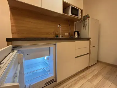 a small kitchen with an open refrigerator in the middle at Old Town Apartments B14 in Kraków