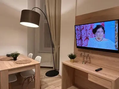 a living room with a television and a table with chairs at Old Town Apartments B14 in Kraków