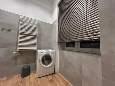 a laundry room with a washing machine and a window at Old Town Apartments B14 in Kraków