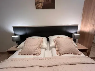 a bed with a black headboard and two pillows at Old Town Apartments B14 in Kraków