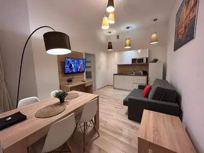 a living room with a dining room table and a couch at Old Town Apartments B14 in Kraków