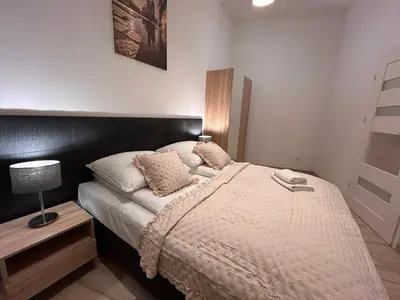 a bedroom with a bed and a table with a lamp at Old Town Apartments B14 in Kraków