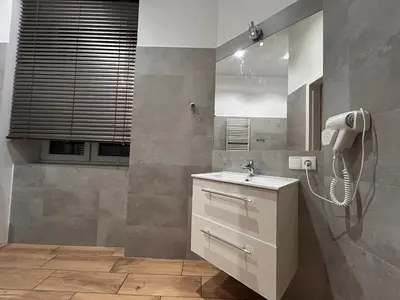 a bathroom with a sink and a phone on the wall at Old Town Apartments B14 in Kraków