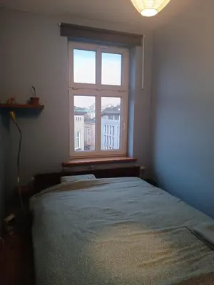 a bedroom with a large bed and a window at Appartement au coeur de Kazimierz in Kraków
