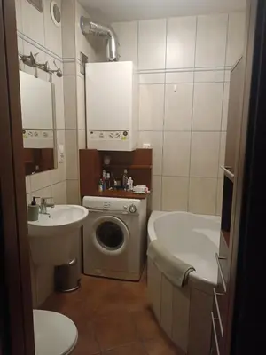 a bathroom with a sink and a washing machine at Appartement au coeur de Kazimierz in Kraków