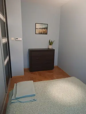 a bedroom with a bed and a dresser in a room at Appartement au coeur de Kazimierz in Kraków