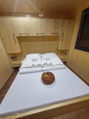 a bed in a cabin with a pumpkin on it at Słoneczny Brzeg Ekskluzywne domki z jacuzzi in Tęgoborze