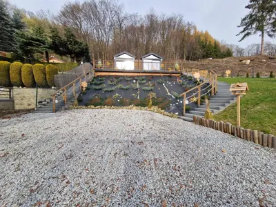 a house with a bunch of flowers on a deck at Słoneczny Brzeg Ekskluzywne domki z jacuzzi in Tęgoborze