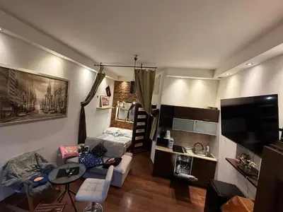 a small living room with a couch and a kitchen at Relax in Kraków