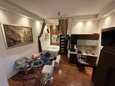 a living room with a couch and a bed and a kitchen at Relax in Kraków