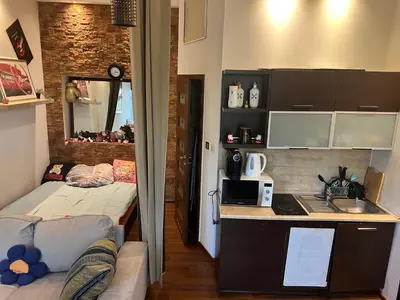 a small room with a bed and a kitchen at Relax in Kraków