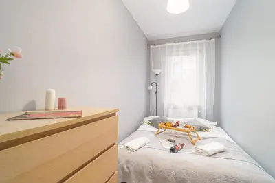 a bedroom with a bed with a wooden doll on it at Kraków Grzegórzki Apartment with Balcony - by Rentujemy in Kraków