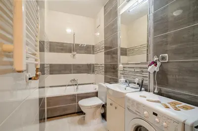 a bathroom with a toilet sink and a washing machine at Kraków Grzegórzki Apartment with Balcony - by Rentujemy in Kraków