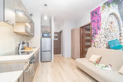 a kitchen with a sink and a couch in a room at Kraków Grzegórzki Apartment with Balcony - by Rentujemy in Kraków