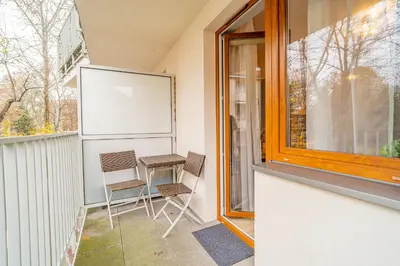 a small balcony with two chairs and a window at Kraków Grzegórzki Apartment with Balcony - by Rentujemy in Kraków