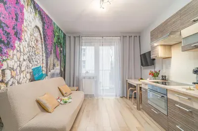 a living room with a couch and a kitchen at Kraków Grzegórzki Apartment with Balcony - by Rentujemy in Kraków
