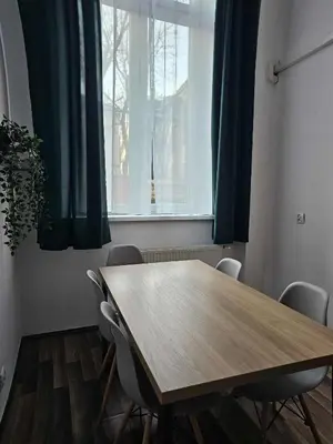 a dining room table with chairs and a window at Cozy Apartment in Krakow in Kraków
