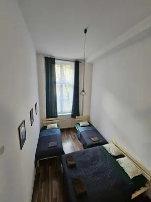 a room with three beds and a window at Cozy Apartment in Krakow in Kraków