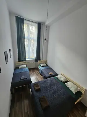 a room with three beds and a window at Cozy Apartment in Krakow in Kraków
