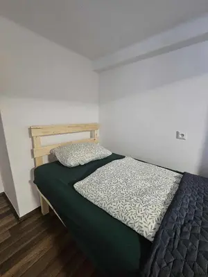 a bedroom with a bed with a green comforter at Cozy Apartment in Krakow in Kraków