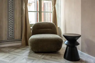 a chair and a table in a room with a window at Nobilis Apartments by MB Apartments in Kraków