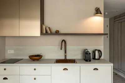 a kitchen with white cabinets and a sink at Nobilis Apartments by MB Apartments in Kraków