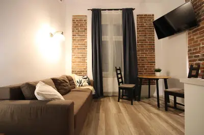 a living room with a couch and a table at Krakow Central Vintage Apartment by Rently in Kraków