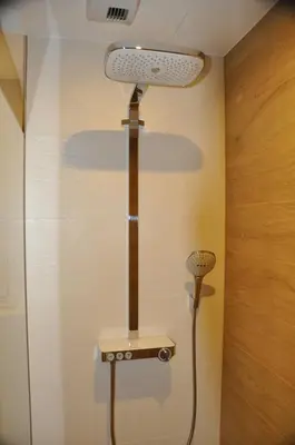 a shower in a room with a light on the wall at Holiday Apartments Browar Lubicz Krakow Stare Miasto in Kraków