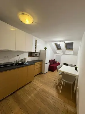 a kitchen with a table and a white refrigerator at Kraków Riverside & Old Town Apartment in Kraków