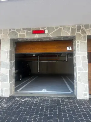 a garage with ajar door in a stone wall at Rabczański Taras z jacuzzi in Rabka