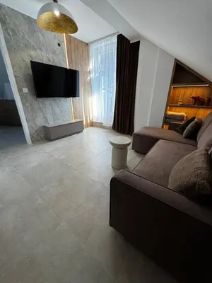 a living room with a couch and a flat screen tv at Rabczański Taras z jacuzzi in Rabka