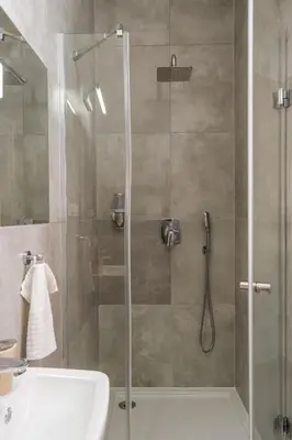 a shower with a glass door next to a sink at Kazimierz Residence Apartments Parking - by Staymoovers in Kraków