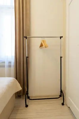 a towel rack next to a bed in a room at Kazimierz Residence Apartments Parking - by Staymoovers in Kraków