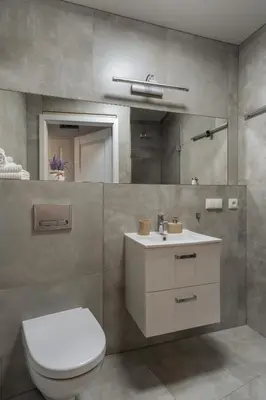 a bathroom with a toilet and a sink and a mirror at Kazimierz Residence Apartments Parking - by Staymoovers in Kraków